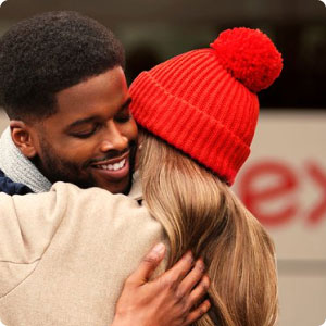 Two people hugging and similing